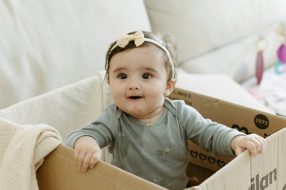 Close-up of folded organic cotton baby onesies in soft natural tones