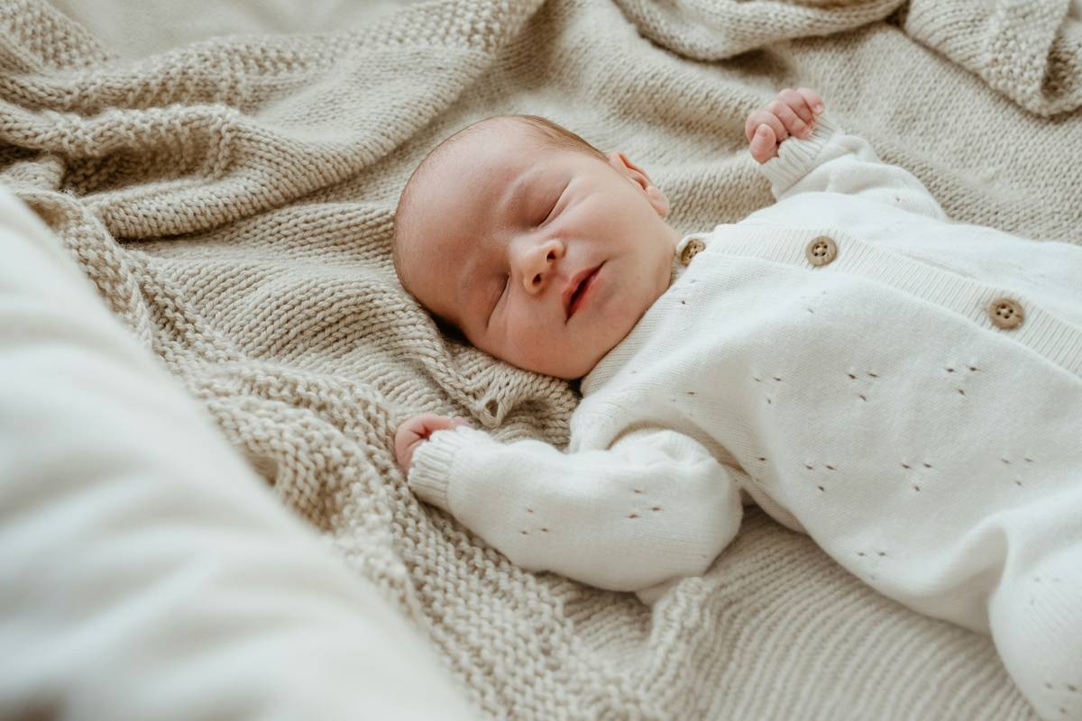 Close-up of GOTS-certified sustainable baby items including organic cotton onesies